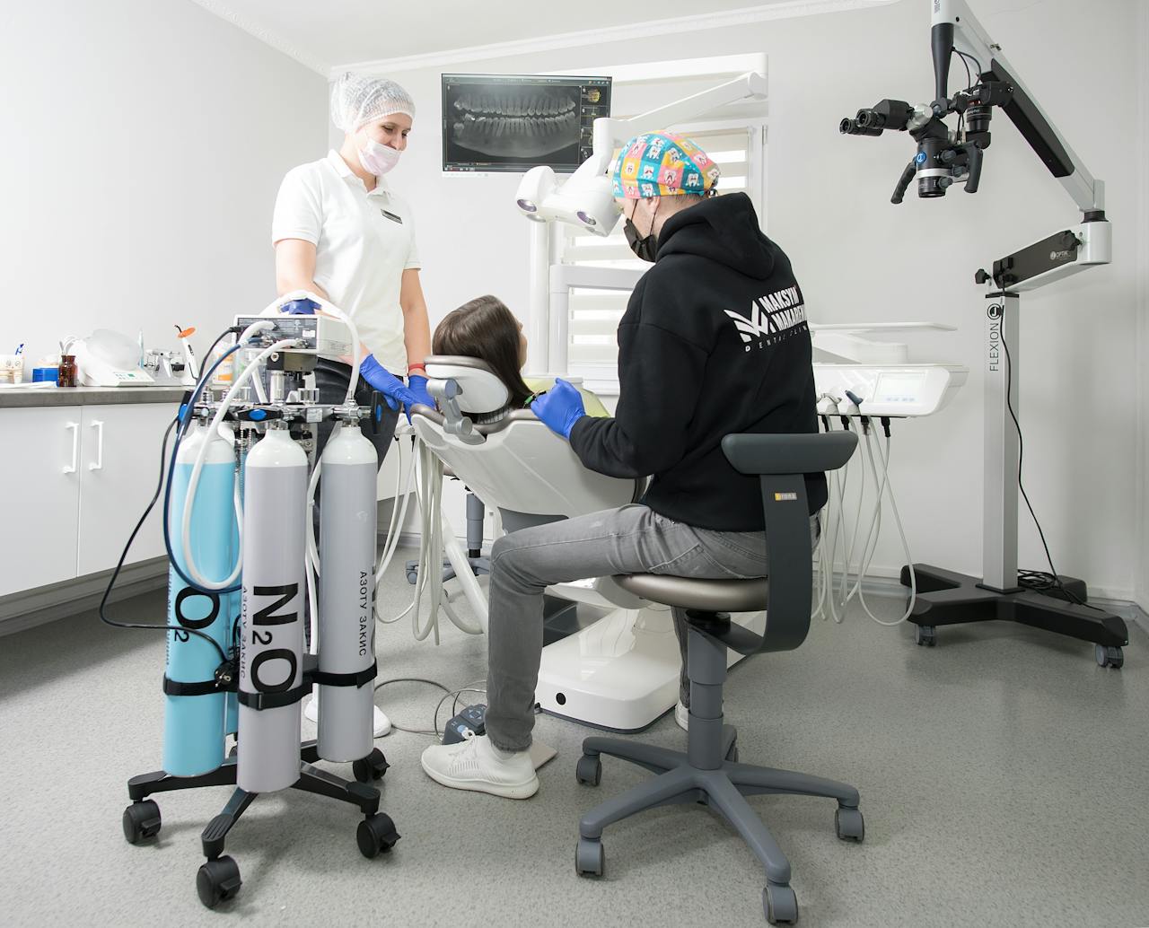 Dentist and assistant performing dental procedure with modern equipment in Kiev clinic.